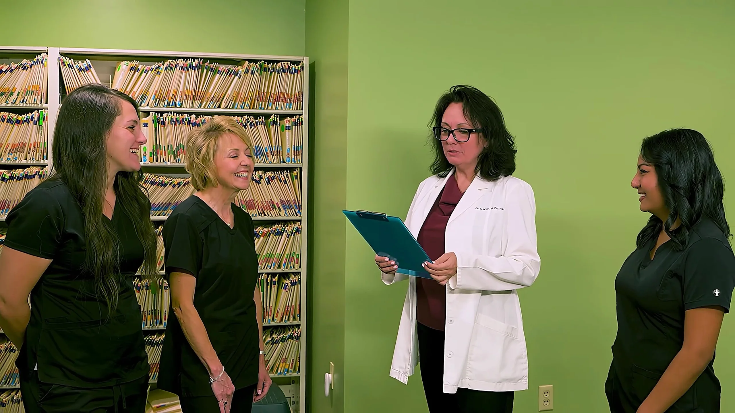 Dr. Acosta reviewing a patient chart with her team at Broadway Dentistry, a general dentistry office in Fort Wayne, Indiana