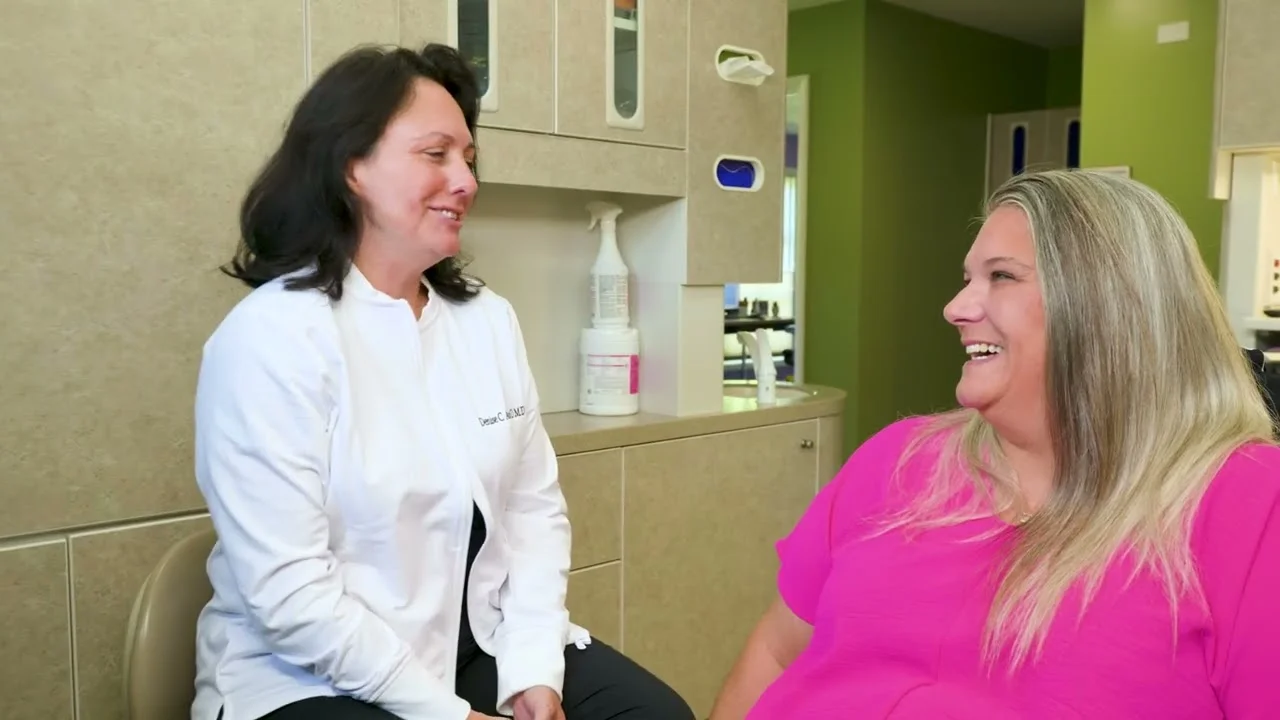 Dr. Denise Acosta talking with a patient in the dental chair at her general dentistry office in Fort Wayne, Indiana