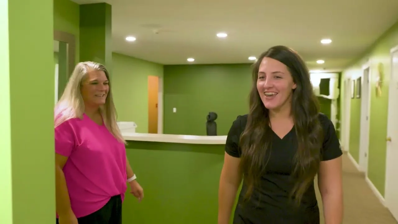 Two Broadway Dentistry team members by the front desk of the general dentistry office in Fort Wayne, Indiana
